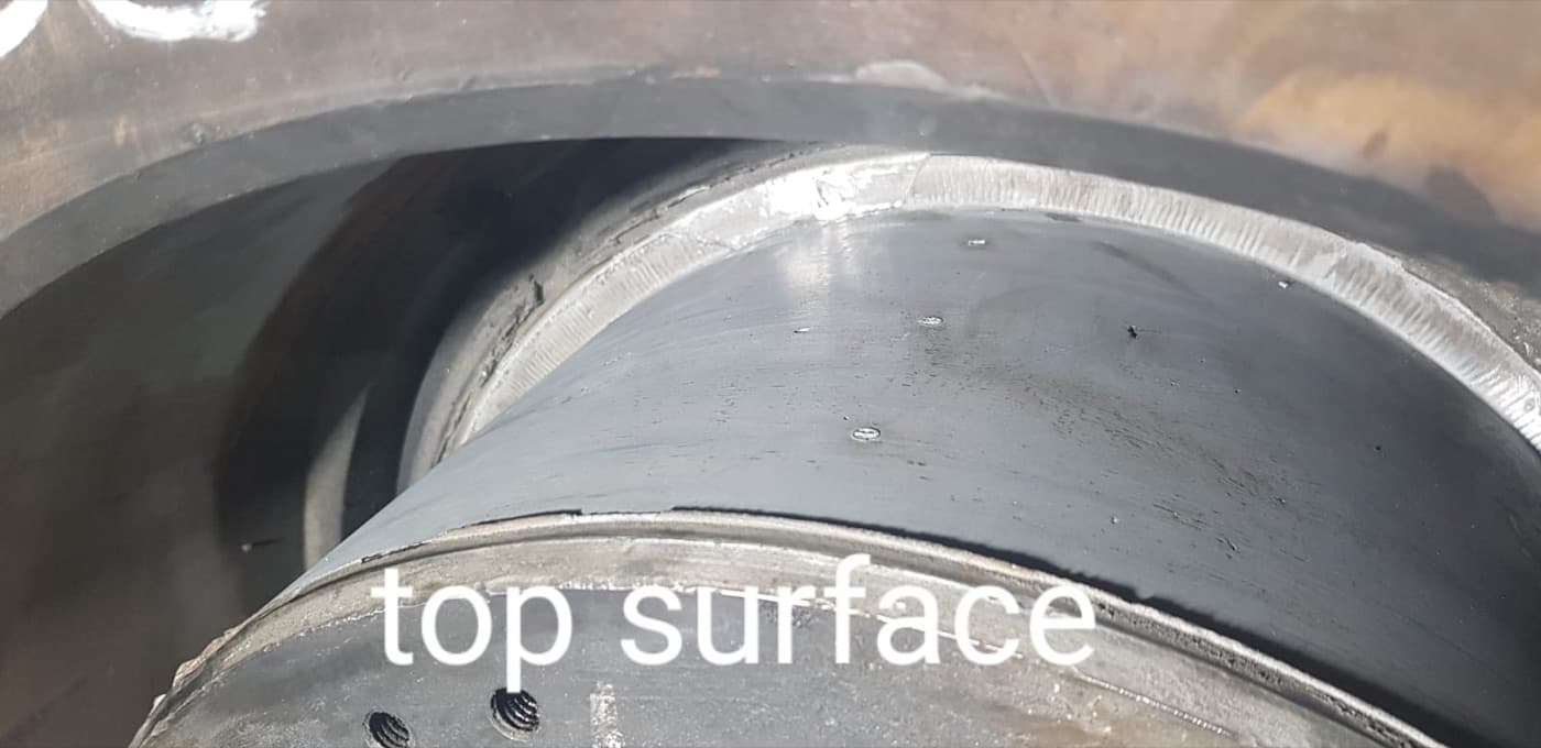 Close-up of a machined bearing bore and shoulder; the words "top surface" are written across the lower part of the photograph
