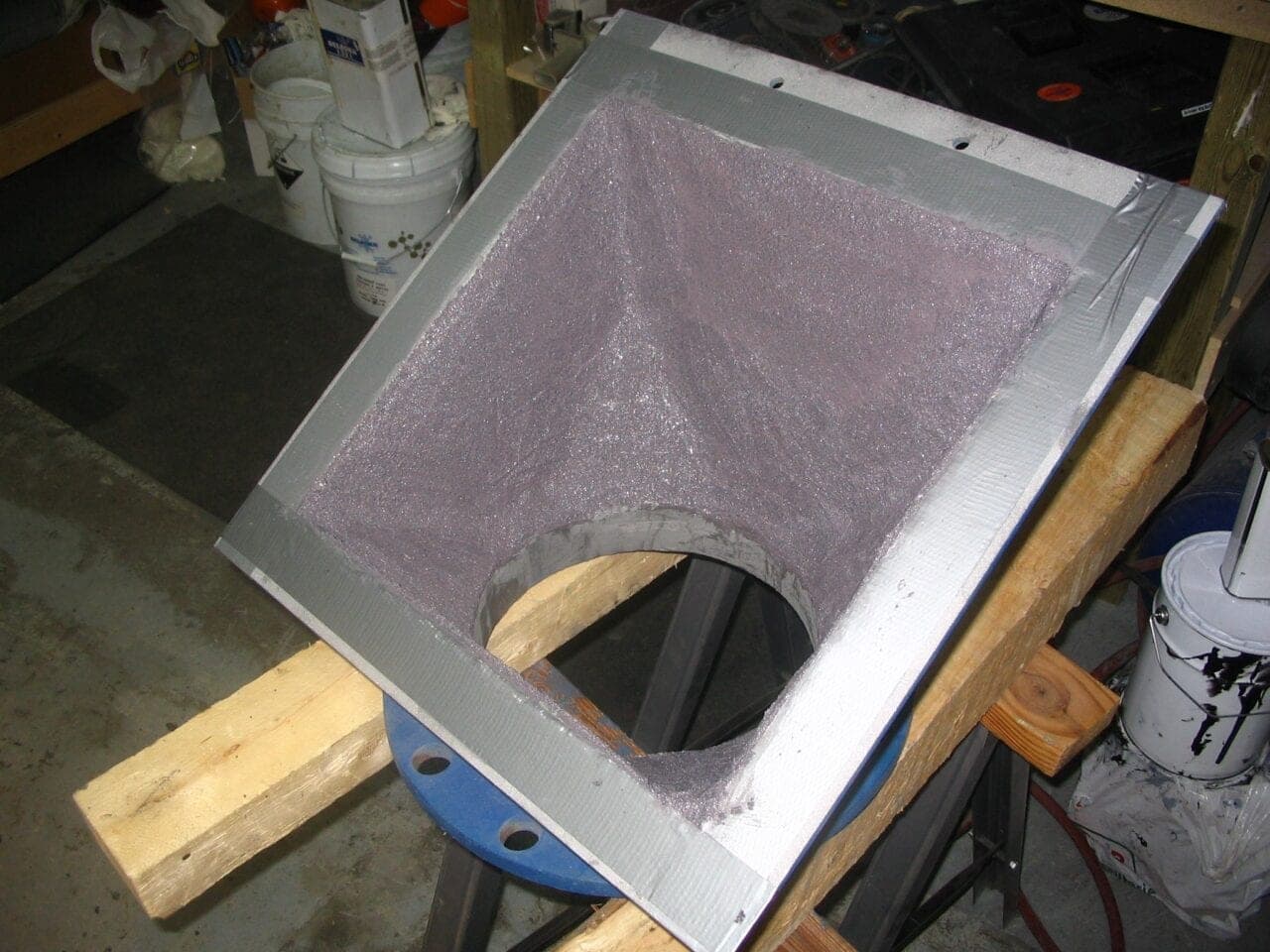 Square transfer hopper section on a bench, its interior lined with a glittering ceramic-filled coating and its edges masked with tape
