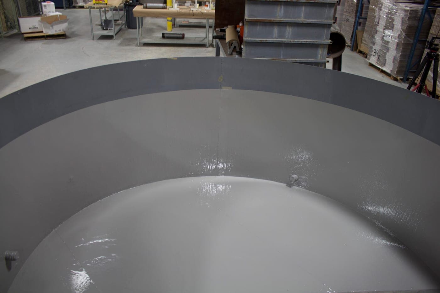 Dished vessel head on a shop floor with a freshly applied two-tone gray internal coating